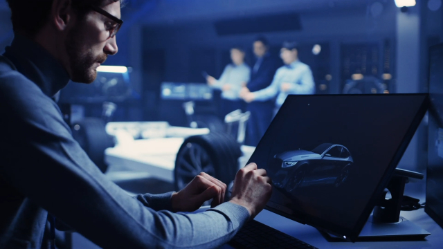 A vehicle performance engineer working with digital design tools to optimize the E/E systems of an electric vehicle.