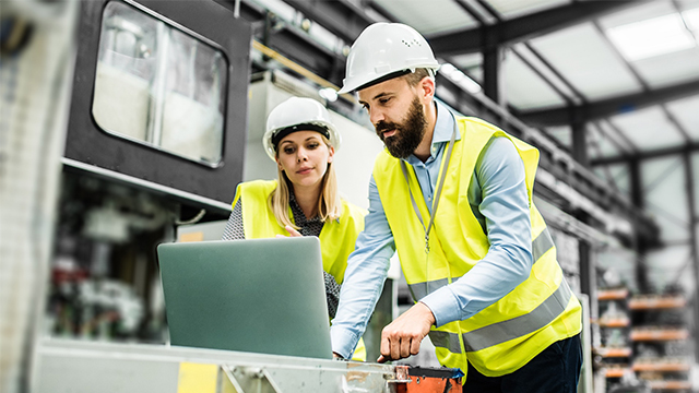 Engineers working on quality management systems in a factory