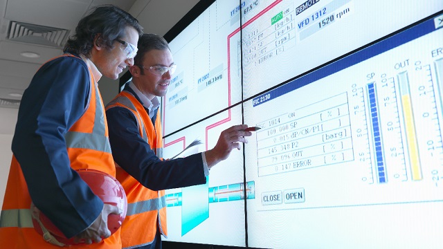 Engineers collaborating in front of large white board