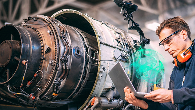 man with laptop in front of jet engine