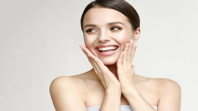 Woman smiling after applying facial cream