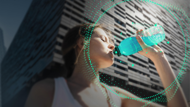 一个女孩在跑步后饮用瓶子中的蓝色能量饮料