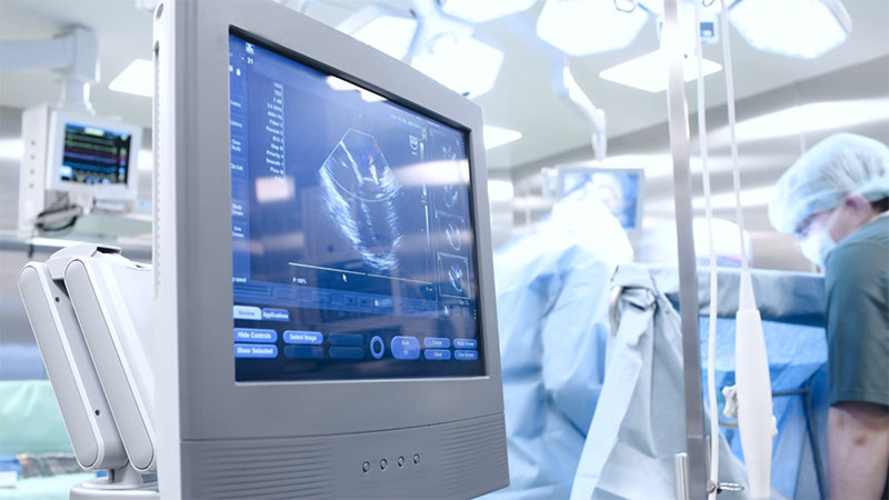 Image of ultrasound on a computer screen while a doctor operates in the OR